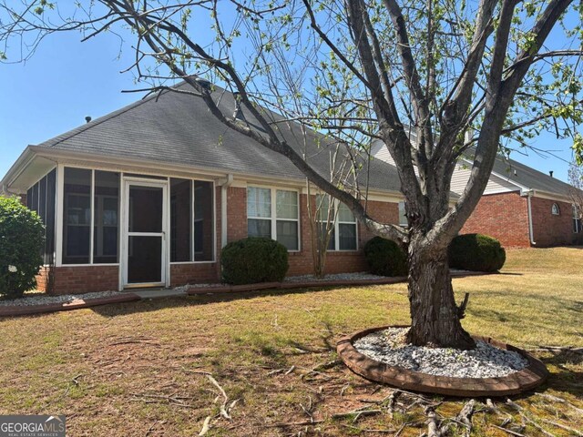1365 Jubilee Ln, Mcdonough, GA 30253 - rear view of property featuring brick siding, a sunroom, and a lawn