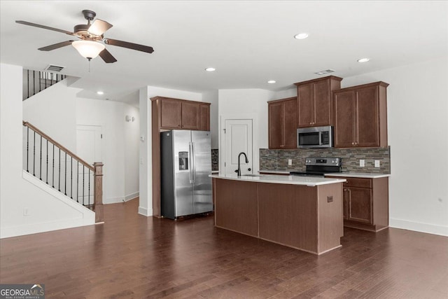 kitchen featuring decorative backsplash, stainless steel appliances, light countertops, dark wood-type flooring, and visible vents