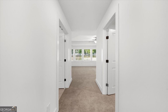 hallway with carpet floors and baseboards