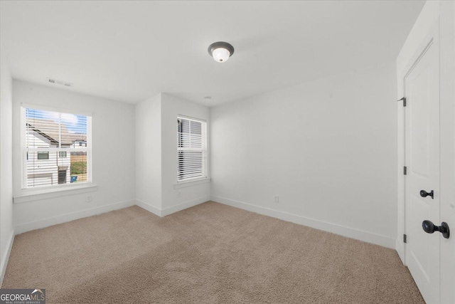 unfurnished bedroom with visible vents, baseboards, and light colored carpet
