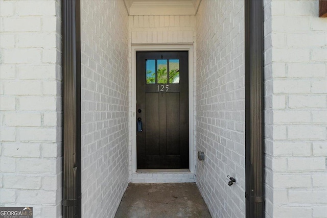 doorway to property with brick siding