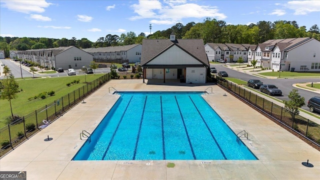 pool featuring fence and a residential view