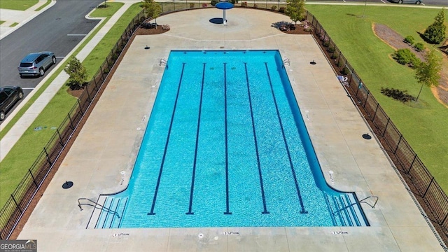 community pool featuring fence and a yard