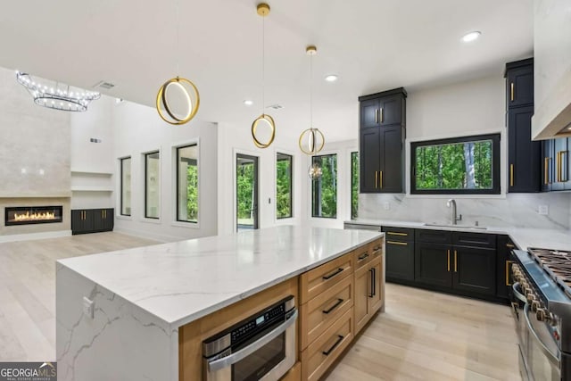 2205 Sugarloaf Pkwy, Lawrenceville, GA 30045 - kitchen with high end range, light stone counters, light wood-style floors, recessed lighting, and backsplash