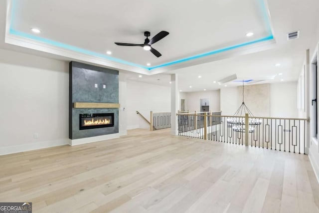 2205 Sugarloaf Pkwy, Lawrenceville, GA 30045 - unfurnished living room featuring a tray ceiling, ceiling fan, wood finished floors, a fireplace, and recessed lighting