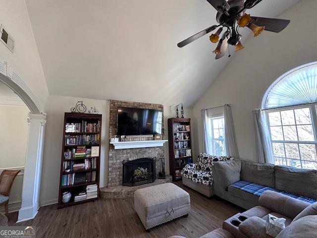 sitting room featuring wood finished floors, a chandelier, arched walkways, and baseboards