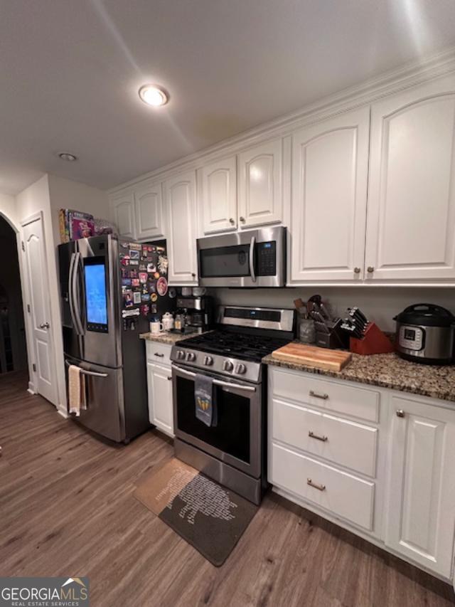 kitchen featuring appliances with stainless steel finishes, dark wood finished floors, and white cabinetry