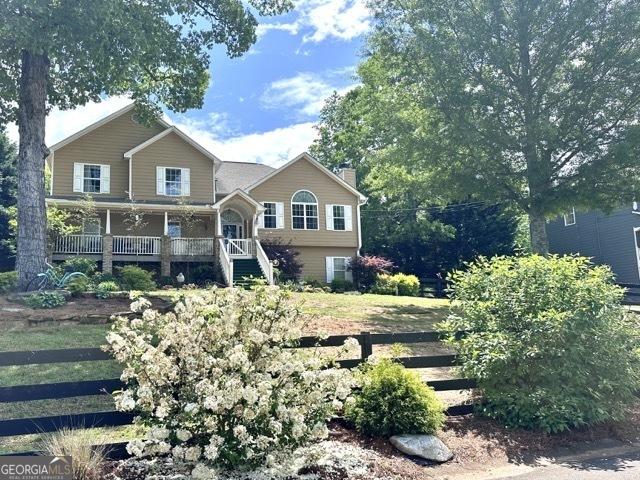 279 S Woods Ct, Jasper, GA 30143 - view of front facade with a chimney, covered porch, and stairway