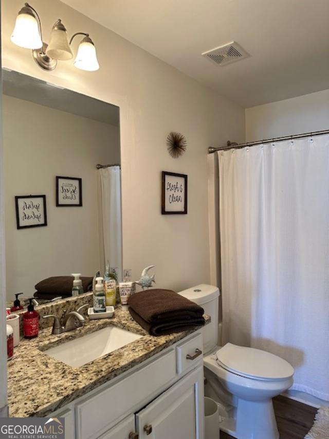 full bath featuring vanity and toilet