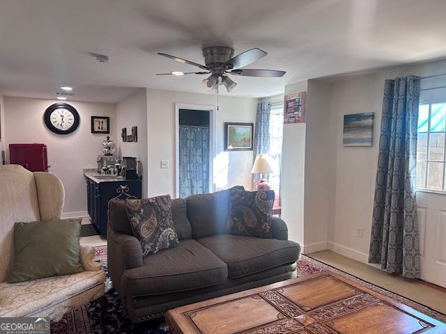living room featuring baseboards, a ceiling fan, and recessed lighting