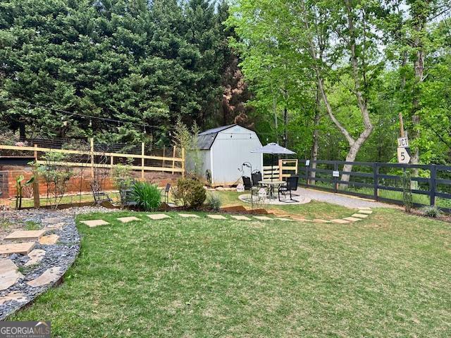 view of yard featuring an outdoor structure and a storage unit