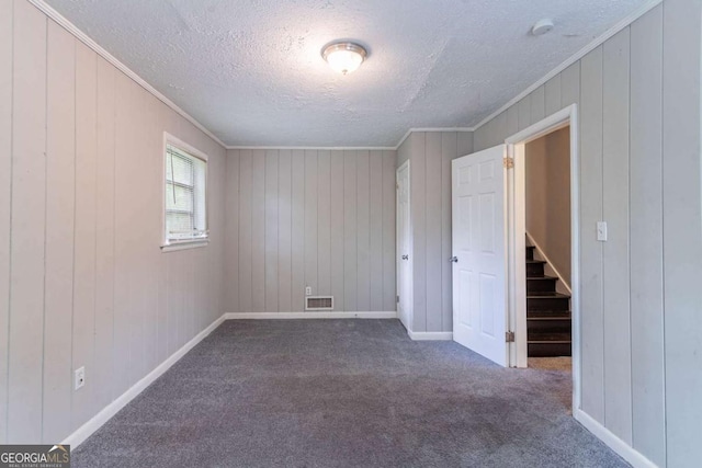 1956 Joseph Ct, Decatur, GA 30032 - carpeted spare room with a textured ceiling, visible vents, stairs, wooden walls, and ornamental molding