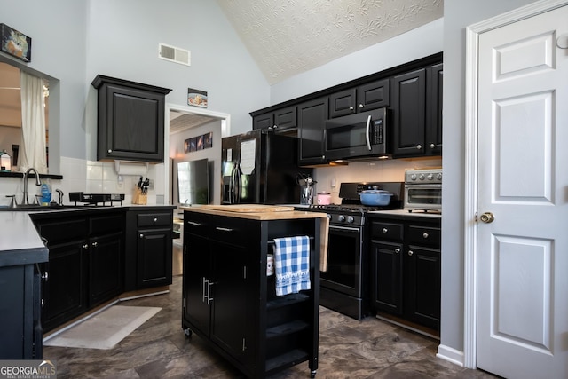 344 River Landing Dr, Monroe, GA 30656 - kitchen with black appliances, dark cabinetry, a sink, a center island, and tasteful backsplash