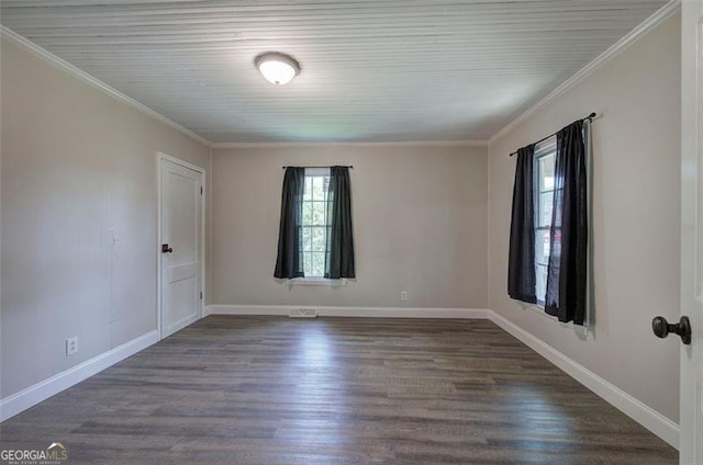empty room with dark wood-type flooring, visible vents, ornamental molding, and baseboards