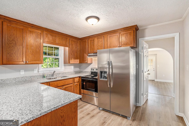 1132 Luther Dr SW, Mableton, GA 30126 - kitchen featuring a sink, brown cabinetry, stainless steel appliances, light wood-style flooring, and under cabinet range hood