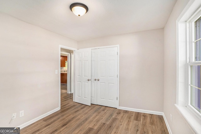 1132 Luther Dr SW, Mableton, GA 30126 - unfurnished bedroom with baseboards, wood finished floors, and a closet