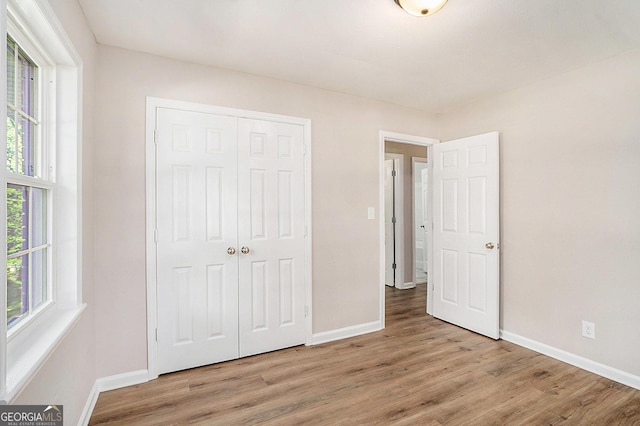 1132 Luther Dr SW, Mableton, GA 30126 - unfurnished bedroom featuring baseboards, multiple windows, and wood finished floors