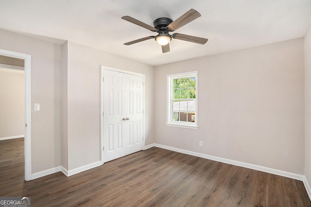 1132 Luther Dr SW, Mableton, GA 30126 - unfurnished bedroom with baseboards, a closet, ceiling fan, and dark wood-style flooring