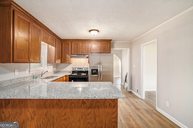 1132 Luther Dr SW, Mableton, GA 30126 - kitchen featuring electric stove, under cabinet range hood, stainless steel fridge, brown cabinetry, and light stone countertops