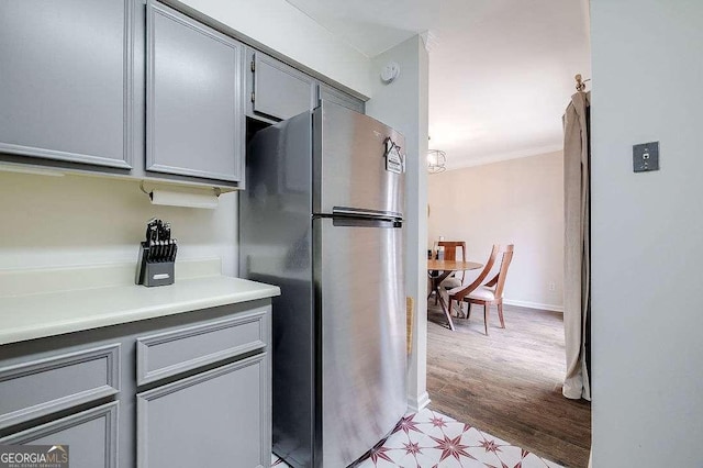 33 Hidden Lake Ct, Savannah, GA 31419 - kitchen with freestanding refrigerator, gray cabinetry, crown molding, light countertops, and light wood-style flooring