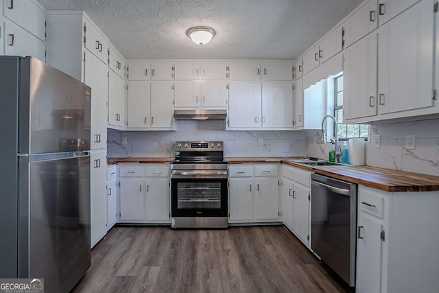 842 Brighton Dr, Lawrenceville, GA 30043 - kitchen featuring white cabinets, under cabinet range hood, dark wood-type flooring, a textured ceiling, and appliances with stainless steel finishes