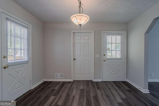 842 Brighton Dr, Lawrenceville, GA 30043 - doorway with baseboards, visible vents, a textured ceiling, and dark wood-type flooring