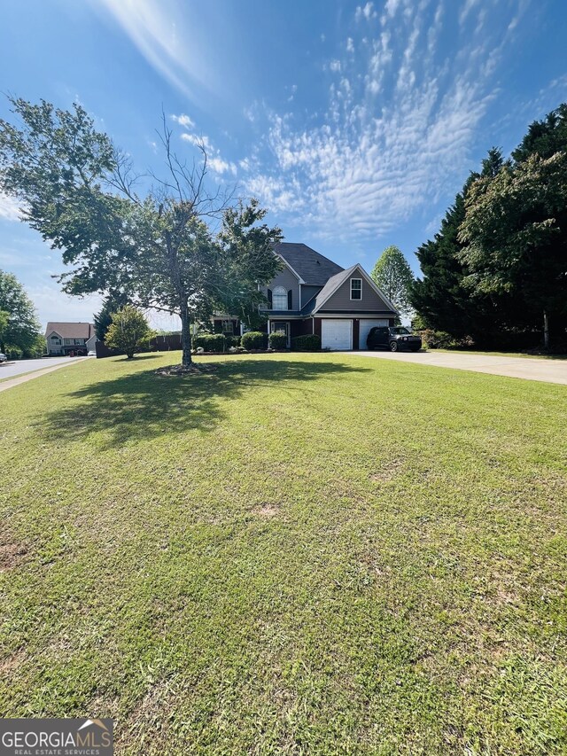 view of front facade with an attached garage, a front lawn, and concrete driveway