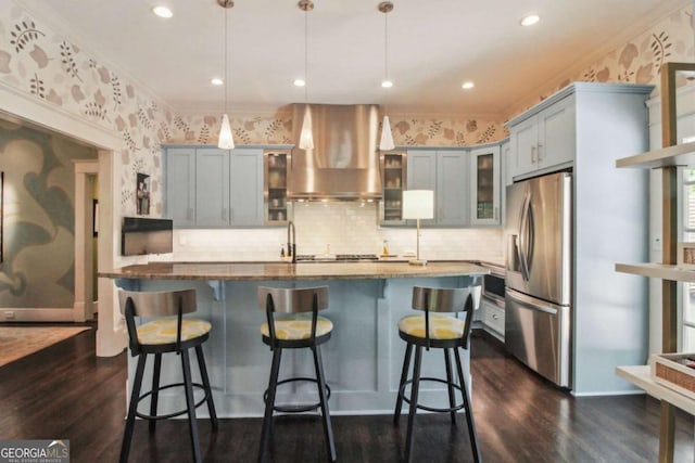 kitchen with wallpapered walls, ventilation hood, stainless steel appliances, and gray cabinetry
