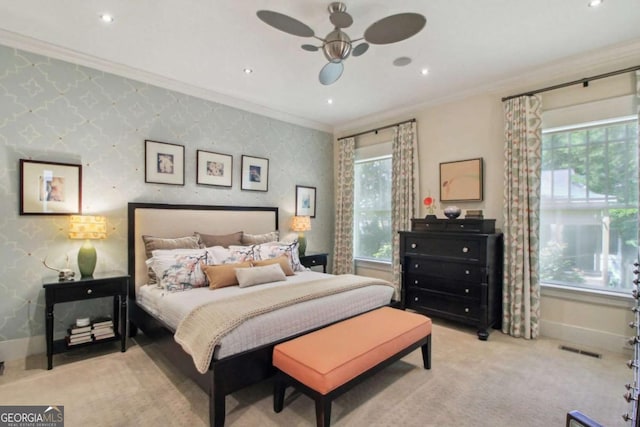 bedroom with baseboards, visible vents, light colored carpet, and crown molding
