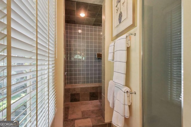 bathroom with tile walls, recessed lighting, and a tile shower