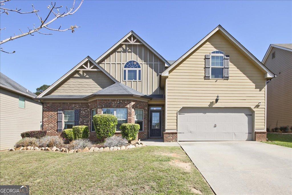 3877 Valley Bluff Ln, Snellville, GA 30039 - craftsman inspired home with a garage, brick siding, board and batten siding, and driveway