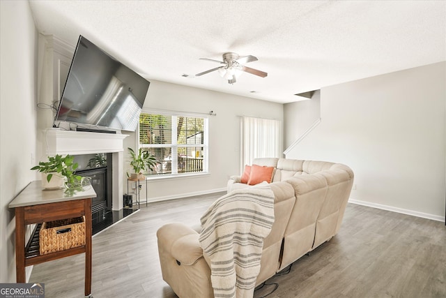 384 Parc River Blvd, Lawrenceville, GA 30046 - living room with ceiling fan, a fireplace with flush hearth, wood finished floors, baseboards, and a textured ceiling