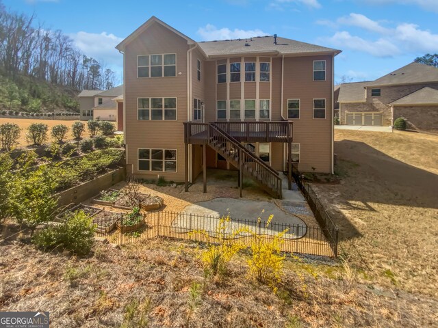 2470 Bridle Bridge Trl, Cumming, GA 30040 - rear view of house featuring fence, a vegetable garden, stairs, and a deck