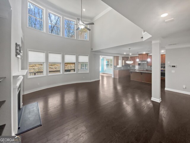 2470 Bridle Bridge Trl, Cumming, GA 30040 - unfurnished living room with ceiling fan, a fireplace, dark wood finished floors, baseboards, and ornamental molding