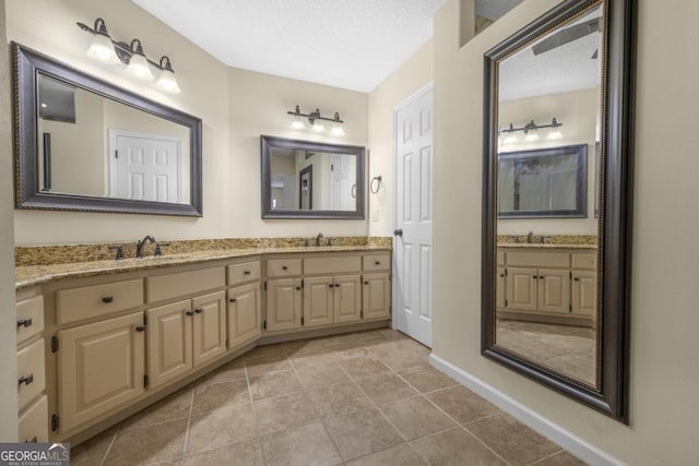 full bathroom featuring double vanity, a textured ceiling, and a sink