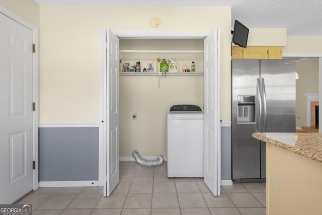 laundry area featuring washer / dryer, baseboards, light tile patterned floors, and laundry area