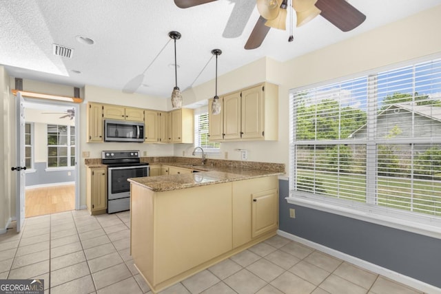 kitchen with stainless steel appliances, a peninsula, visible vents, baseboards, and a ceiling fan