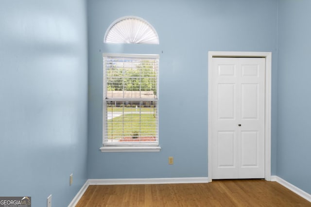 unfurnished room with wood finished floors and baseboards