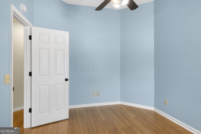 spare room with ceiling fan, baseboards, and wood finished floors