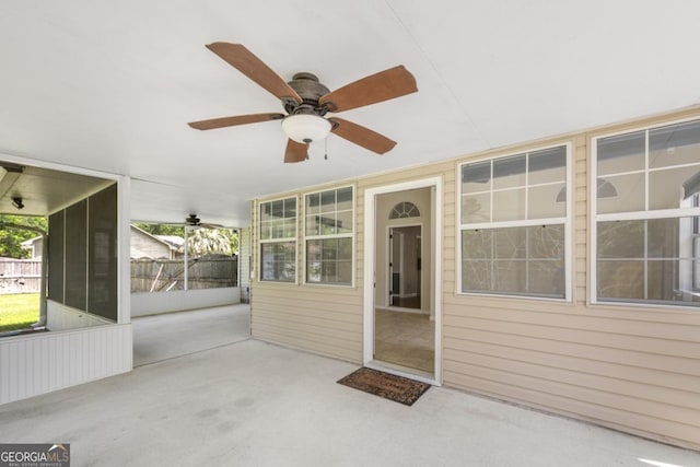 unfurnished sunroom featuring a ceiling fan
