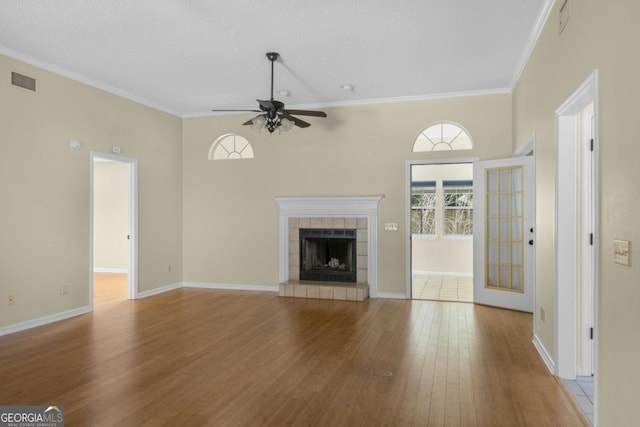 unfurnished living room with crown molding, a ceiling fan, wood finished floors, and visible vents
