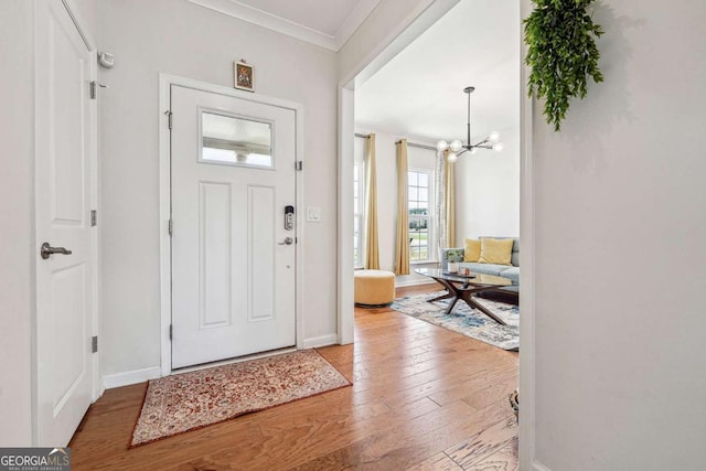 2815 Paddle Point Ln, Cumming, GA 30041 - entrance foyer with hardwood / wood-style flooring, an inviting chandelier, crown molding, and baseboards