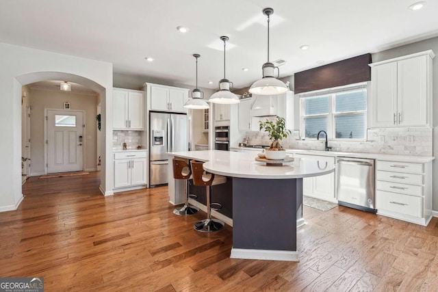 2815 Paddle Point Ln, Cumming, GA 30041 - kitchen featuring white cabinets, stainless steel appliances, light countertops, backsplash, and a kitchen island