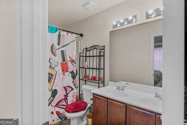 full bath with a sink, curtained shower, toilet, and double vanity