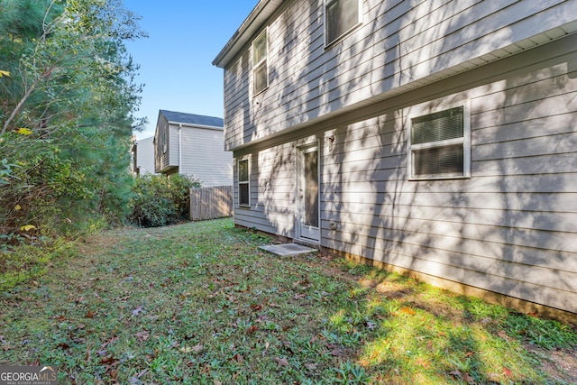 view of property exterior featuring a yard and fence