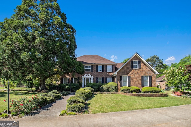 view of front of home with brick siding and a front lawn