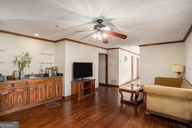 living area with a ceiling fan, dark wood-style floors, a textured ceiling, ornamental molding, and recessed lighting