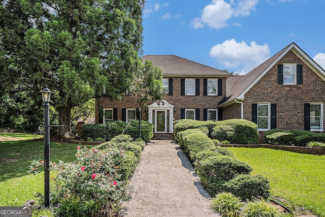 view of front of home featuring brick siding and a front lawn