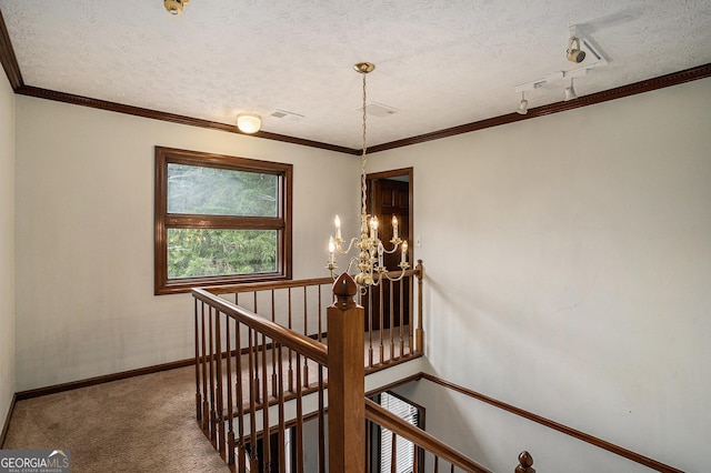 stairway with carpet, a textured ceiling, a chandelier, baseboards, and rail lighting