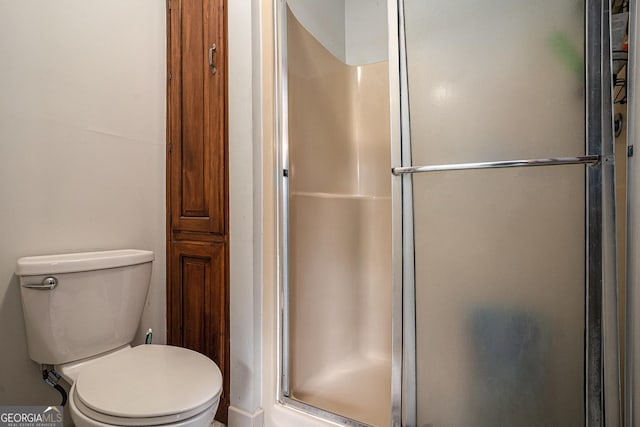 full bathroom with a shower stall and toilet